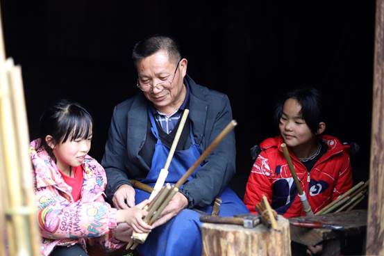 说明: D:\360极速浏览器下载\1.非遗传承人粟德军正在指导小学生学习芦笙吹奏技巧。.jpg