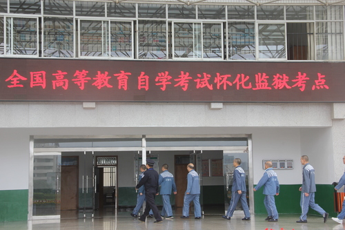 怀化监狱考点参加自考的服刑人员在民警的组织下进入考场 怀化监狱考点参加自考的服刑人员在民警的组织下进入考场